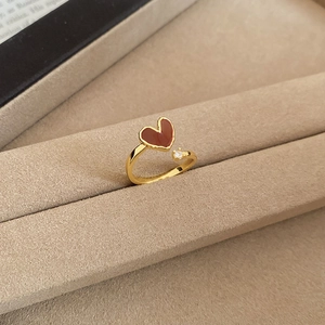 Macro detail of 18k gold plated ring with deep red heart oil drip and cubic zirconia