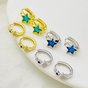 Detailed macro view of star-shaped hoop earrings with blue crystals and enamel inlay