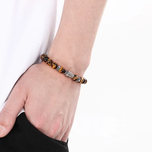 Detailed view of Buddha head bead on Tiger Eye stone bracelet worn on a wrist