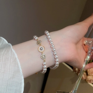 Gros plan de bracelets en perles plaqués or 18 carats avec pendentif soleil en zircon