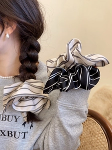 Detail of satin striped scrunchie showing smooth texture and elastic design for ponytails