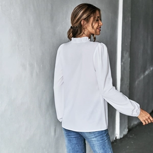 Detail des Rüschen-Stehkragens und Puffärmels an der weißen Langarm-Chiffonbluse