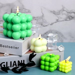 Detail showing lighted bubble candles in mint and yellow on minimalist decor