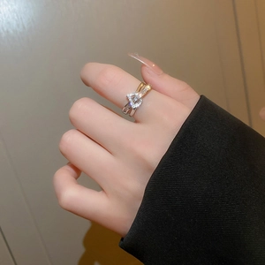 Detail of a two-tone criss-cross ring with pavé cubic zirconia worn on a finger
