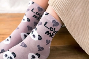 Detail of purple cotton socks featuring panda and heart patterns with LOVE ME text