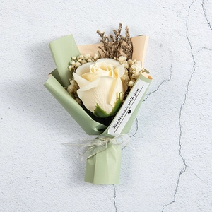 Mini soap rose bouquet with dried baby's breath flowers in pink and green paper wrapping