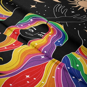 Detail shot of bohemian tapestry fabric showing vivid rainbow character and celestial patterns