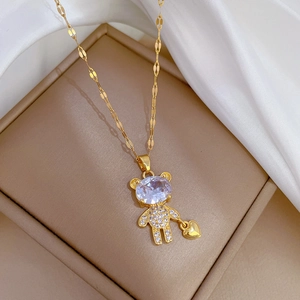 Detail view of a bear necklace in gold finish with micro-pave crystals and a heart charm