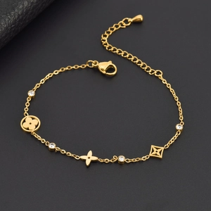 Vue détaillée du bracelet en acier doré avec trèfle, étoiles et cristaux transparents