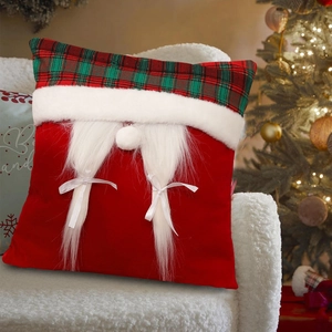 Christmas gnome decorative pillow with red green plaid and white fur braids on a white chair