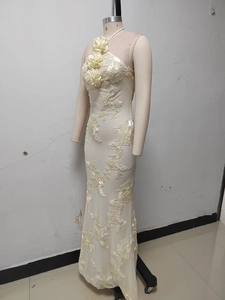Detailed close-up of cream halter gown featuring 3D floral embroidery and mermaid silhouette
