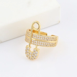 Detailed close-up of golden safety pin ring with shimmering white cubic zirconia pave