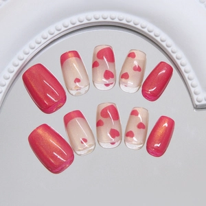 Cat eye press-on nails with rose pink heart patterns and French tips on a mirror surface