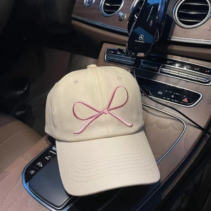 Close-up of pink bow embroidery on beige cotton twill baseball cap for women
