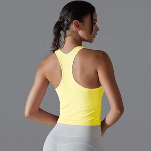 Détail du haut de yoga jaune à dos nageur avec texture côtelée verticale sur fond gris neutre