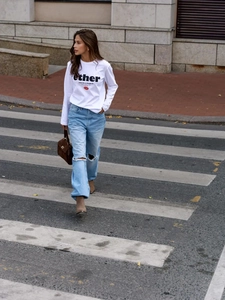 Street style εμφάνιση με λευκό μπλουζάκι, μπλε σκισμένο τζιν και καφέ τσάντα χειρός