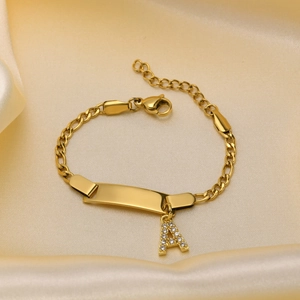 Detail of a gold Figaro chain bracelet with engraved plaque and pavé letter A pendant