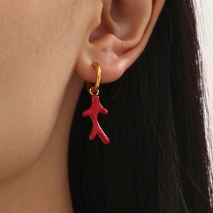 Elegant red coral bead earrings with gold plating on a model for a sophisticated look