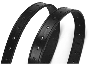 Macro shot of black leather belt featuring decorative star-shaped cutouts and fine stitching