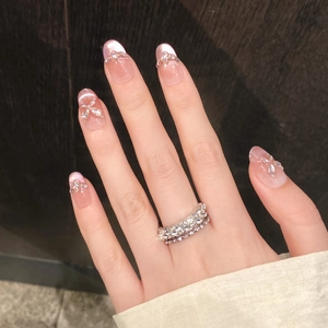 Detail of pink cat eye nails with silver 3D bows, pearls and gradient finish