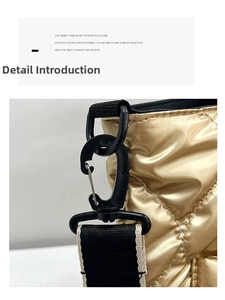 Detailed close-up of quilted gold metallic crossbody bag with black nylon strap and hooks