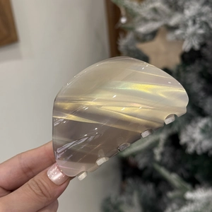 Detailed close-up of a semi-transparent gray acetate hair claw clip with golden shimmer