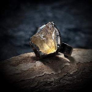 Macro shot of raw yellow crystal stone on vintage textured metal ring setting