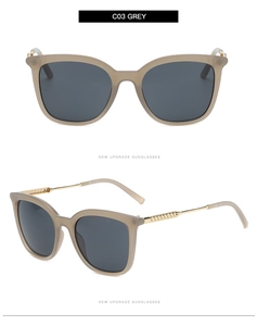 Detail view of grey lenses and beige hollow frames on metal arm sunglasses