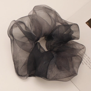 Detailed macro shot of the pleated black organza texture on the oversized scrunchie