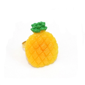 Détail d'un rond de serviette ananas jaune avec feuilles vertes et anneau doré en métal