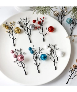 Close-up of colorful glitter berry stems on a white ceramic plate for Christmas decor