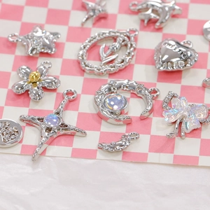 Macro detail of silver alloy charms including stars, bows and crosses for DIY jewelry