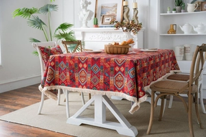 Detail of red jacquard tablecloth with geometric patterns and decorative tassels