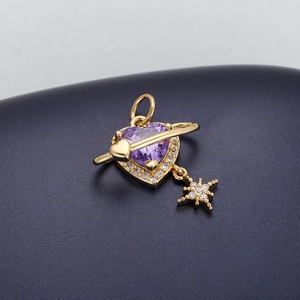 Macro detail of golden heart pendant with purple gemstone and star charm details