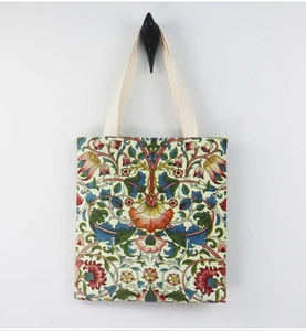 Detail view of William Morris floral canvas tote bag hanging on a minimalist black hook