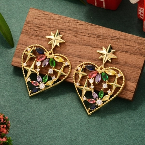 Close-up of golden heart earrings with colorful zircons on a dark wooden surface