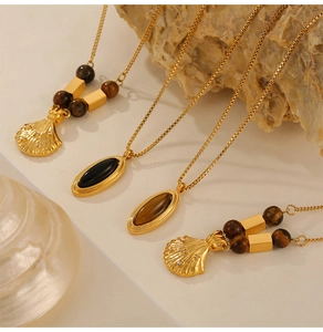 Detail of vintage gold necklaces with tiger eye shell pendants and elegant bead accents