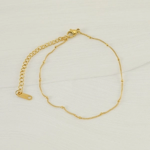 Detail of gold titanium steel anklet with lobster clasp and adjustable extension chain