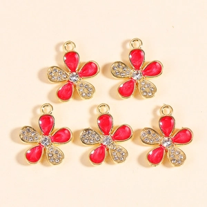 Detailed view of five red enamel flower charms with gold edges and inlaid white rhinestones
