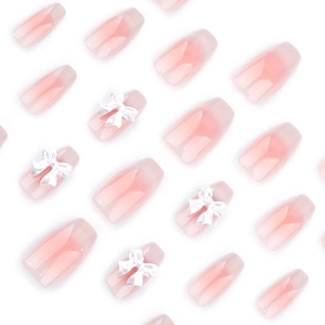 Pink cat-eye gradient press-on nails with 3D white bowknot accents in ballerina shape
