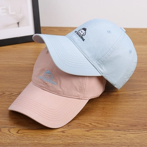 Detail of embroidered cartoon characters on soft fleece baseball caps in pastel colors