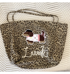 Close-up of leopard print tote bag featuring a cute dachshund embroidery and Luuki logo