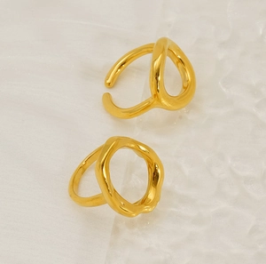 Close-up of golden irregular geometric 18K plated ring on wavy textured background