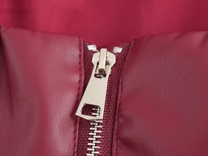 Gros plan détaillé de la fermeture éclair en métal sur une veste en similicuir rouge vif