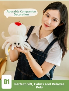 Detail of white plush spider toy with red heart embroidery and soft long-fur texture