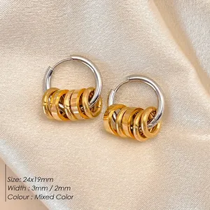 Two-tone stainless steel hoop earrings with hanging gold rings on champagne silk