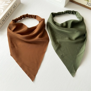 Detail of silk-like triangle bandanas in brown and green with elastic bands for hair