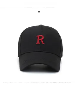 Dettaglio ravvicinato di un cappello nero in cotone con lettera R ricamata in rosso