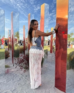 Dettaglio del set festivo in pizzo bianco con maniche a balze e borsa a sella blu