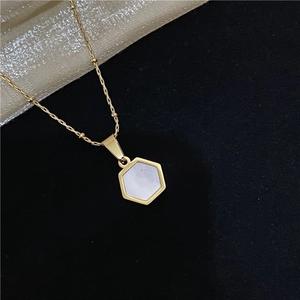 Macro shot of 18k gold plated necklace with hexagonal natural mother-of-pearl pendant